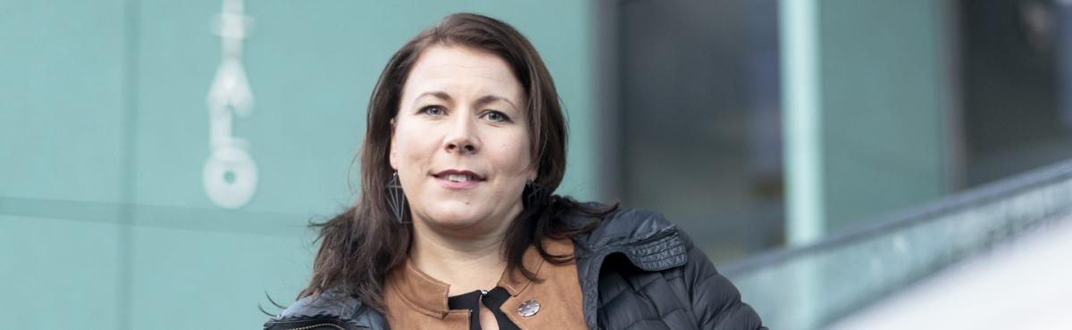 Nainen katsoo kameraan.